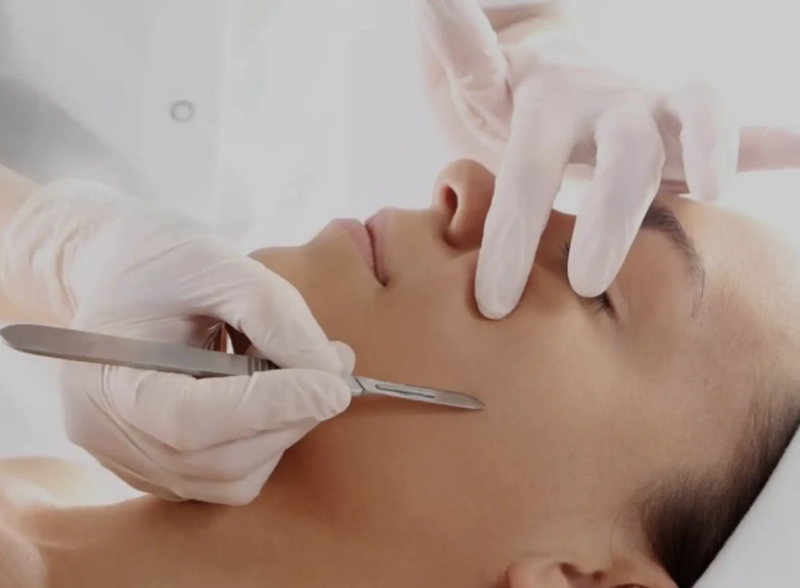 Dermaplaning blade close-up on skin